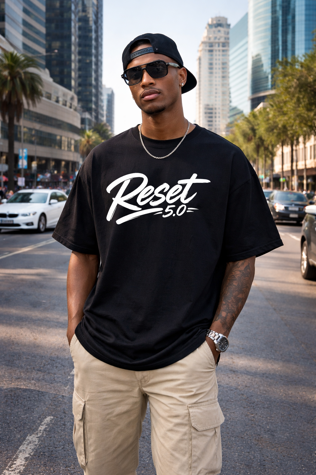 Man wearing a black t-shirt with 'Reset 5.0' on a city street
