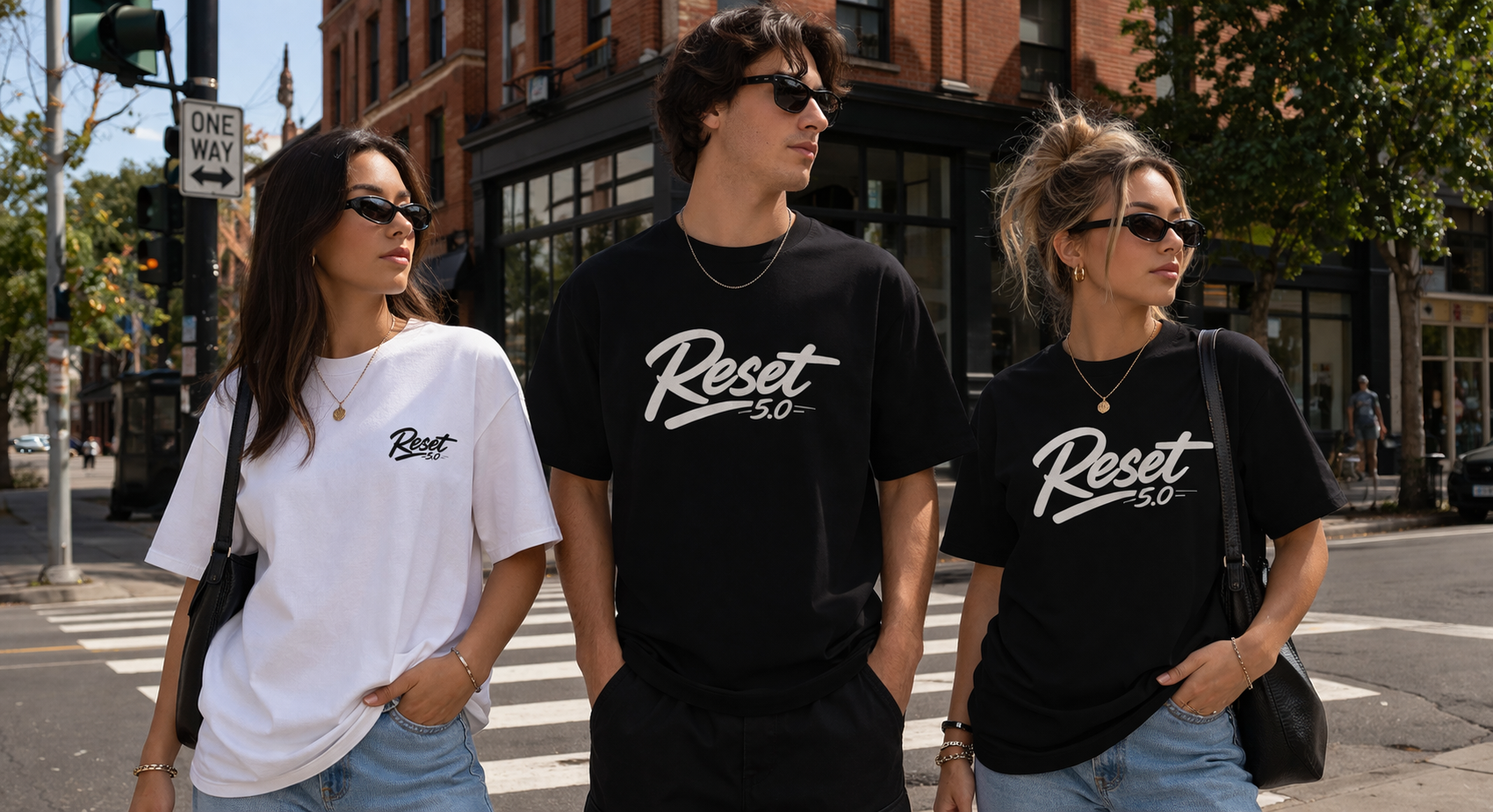 Three people wearing 'Reset 5.0' t-shirts walking on a city street.