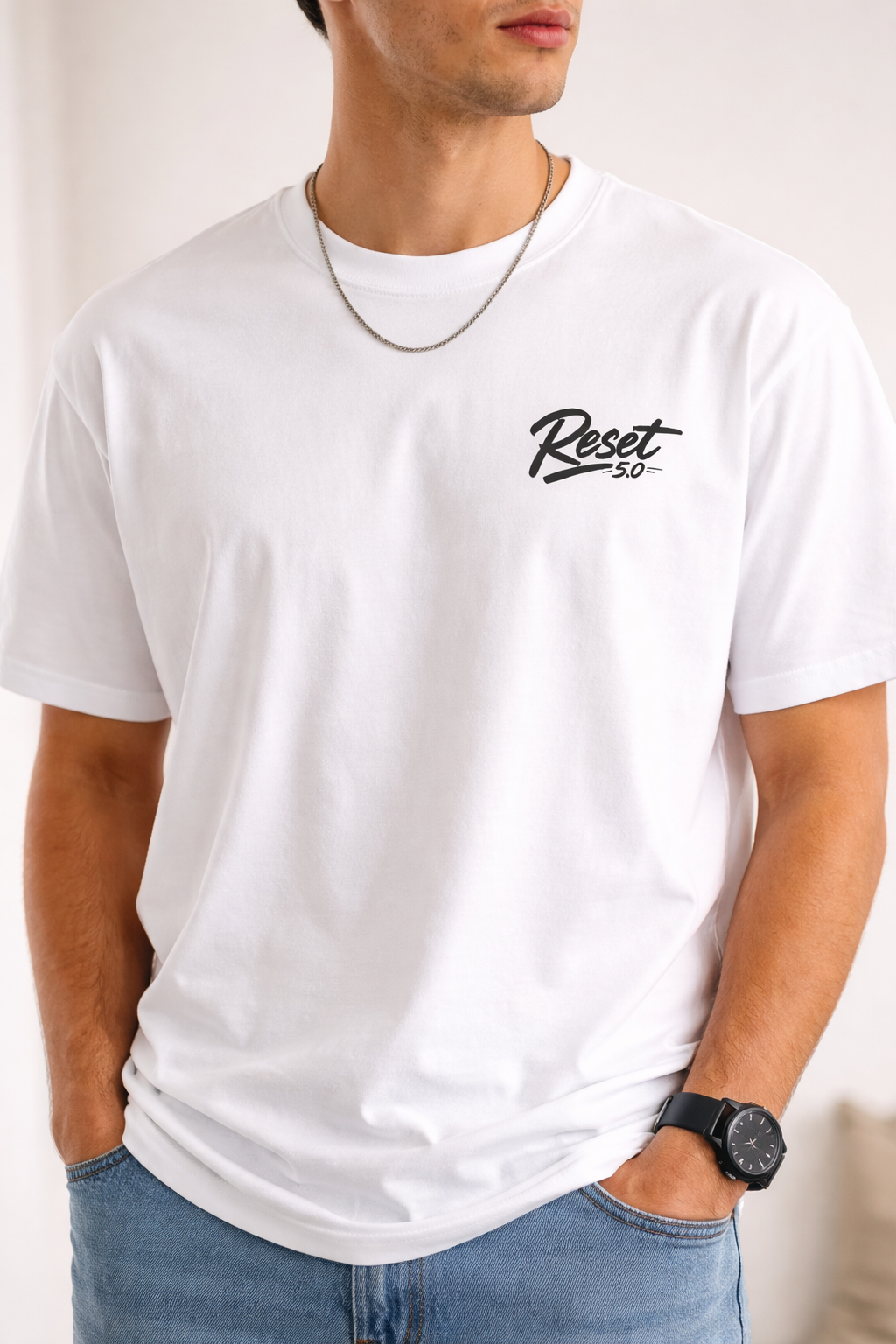 Person wearing a white t-shirt with 'Reset 50' logo on a plain background